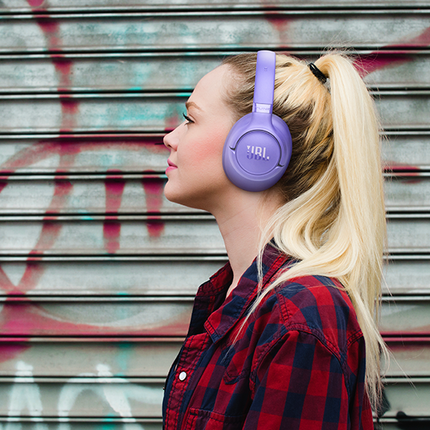 Слушалки JBL Tune 730BT, лавандулови, носени в града, в профил