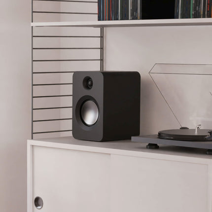 Kanto Audio REN в черен цвят на етажерка, до грамофон