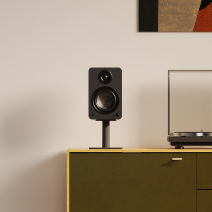 Черна тонколона върху черна стойка Kanto Audio SP6HD на скрин