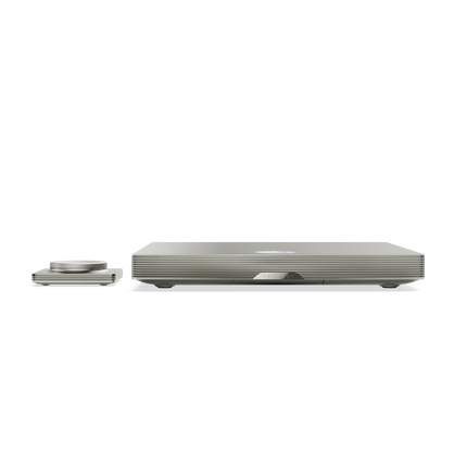 Profilul lateral al lui Devialet Astra Light Bronze, cu nervurile carcasei, și telecomanda alăturată