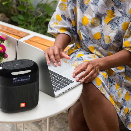 JBL Tuner XL на маса навън, до лаптоп